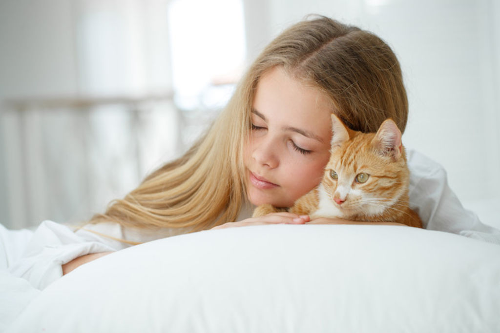 Fille avec chat sur lit