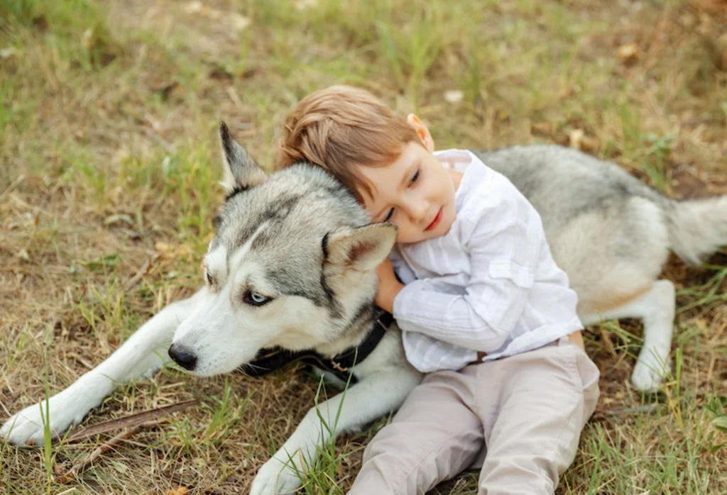 Jong kind knuffelt liggende hond